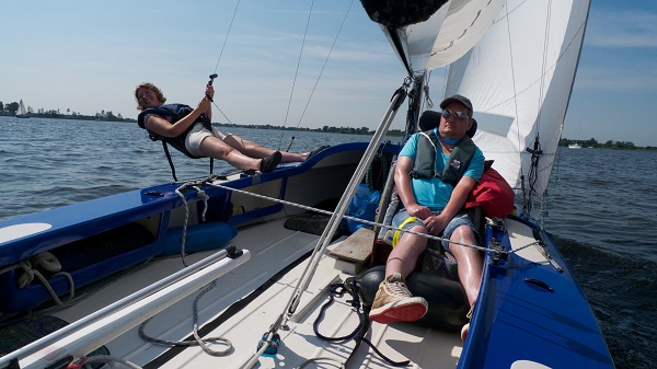 Blogger Ank hangt boven het water aan de trapeze van de zeilboot